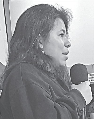 Photograph of Abbie Arevalo Herrera, a young Hondoran woman, speaking into a microphone. 
