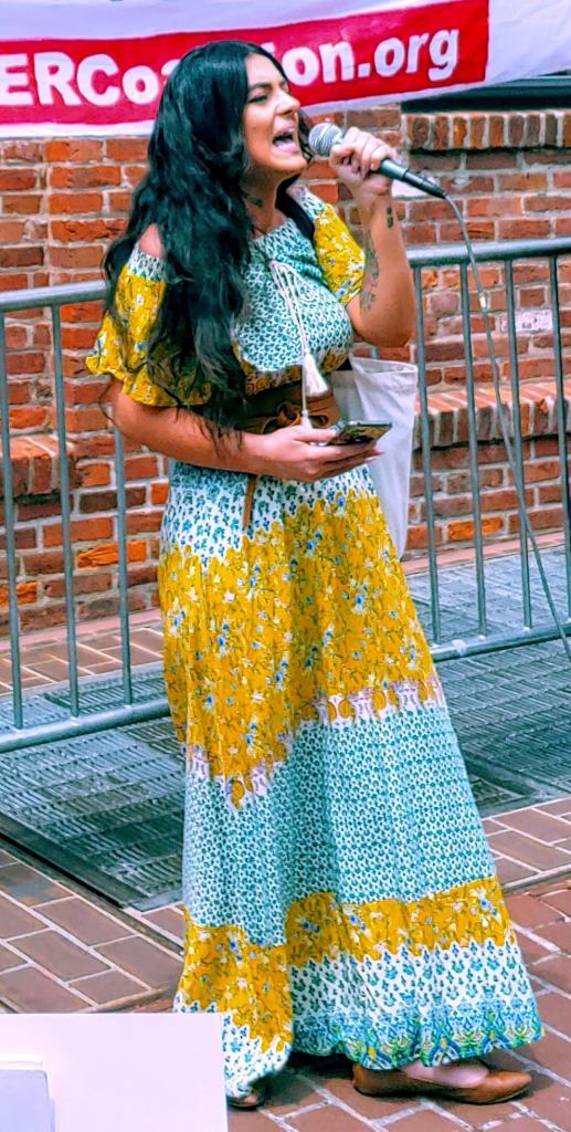 Photo of a Latina woman speaking into a microphone.